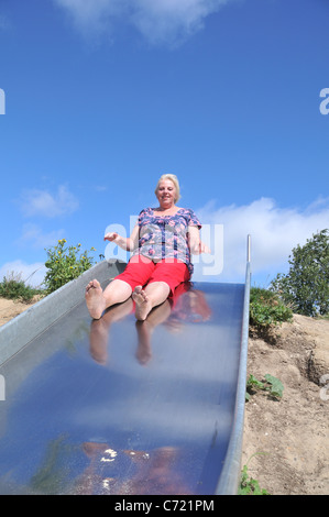 A senior woman having fun on a slide Stock Photo