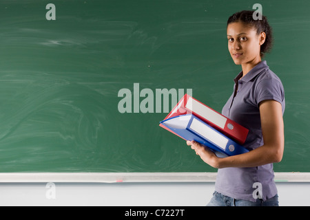 adult teacher is standing near chalkboard Stock Photo