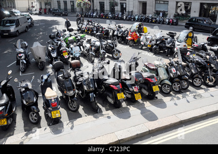 Looking down from above London street scene motorbike motorcycle & scooter parking bays in road in Berkeley Square Mayfair West End London England UK Stock Photo