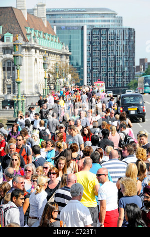 Crowd of people on London tourism street  summer view from above looking down on crowds of tourists walking along pavement at Westminster Bridge UK Stock Photo