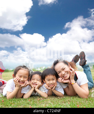 happy asian family on the grass with cloud background