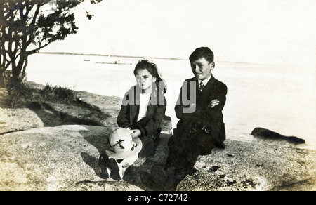 The photo, which dates to around 1921, shows a brother and sister on the rocks on Cape Cod, Massachusetts. Stock Photo