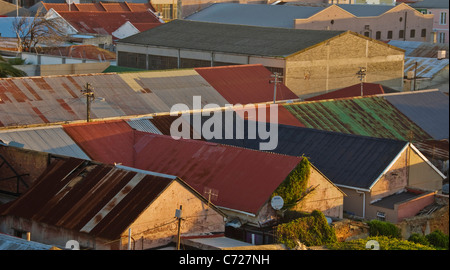 Old pitched roofs of many colors, made from corrugated iron and in a variety of conditions. Woodstock, Cape Town. Stock Photo