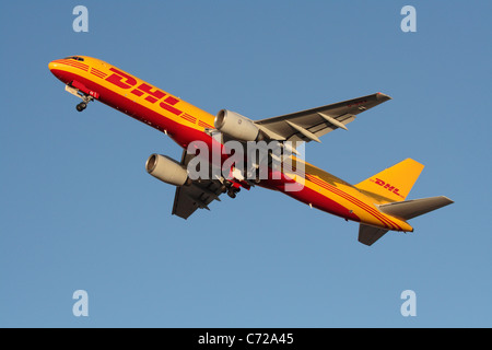 Freight transport by air. DHL Boeing 757-200F cargo jet plane taking off at sunset. International trade. Global route network. Civil aviation. Stock Photo