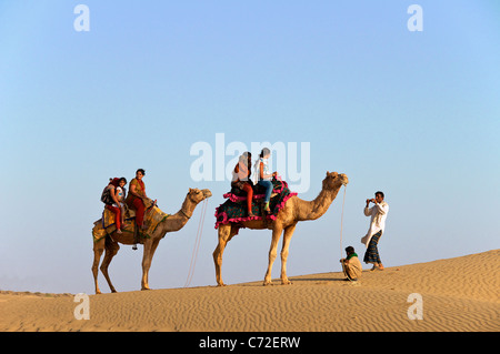 Indian tourists on camels having photos taken Sam Dunes Desert National Park Western Rajasthan India