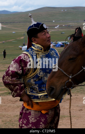 Mongolian Man in traditional clothing, Horse racing competition, Naadam Festival (horse racing ground), Ulaanbaatar, Mongolia. credit: Kraig Lieb Stock Photo