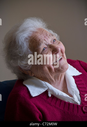 Elderly lady happy seated looking up to carer family friend smiling senior old age elderly lady in her living room Stock Photo