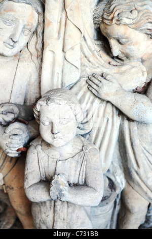 Stone statue praying with child - religious symbol Stock Photo