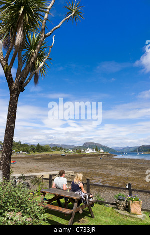 Couple looking out over Loch Carron from the terrace of a pub in the picturesque village of Plockton, Highland, Scotland, UK Stock Photo