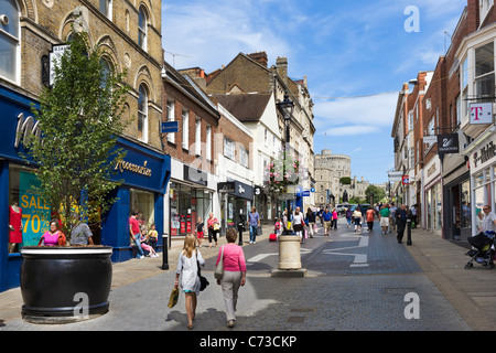 Shops on Peascod Street in the town centre with Windsor Castle in the distance, Windsor, Berkshire, England, UK Stock Photo
