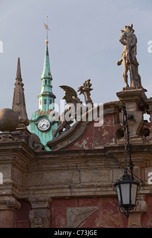 Sculptures on the gates to Bueckeburg Palace with clock tower of the town hall in the background Bueckeburg Lower Saxony norther