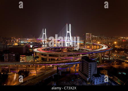 High angle wide shot traffic on Nanpu Bridge spiral, illuminated Bridge at night, Shanghai, China Stock Photo