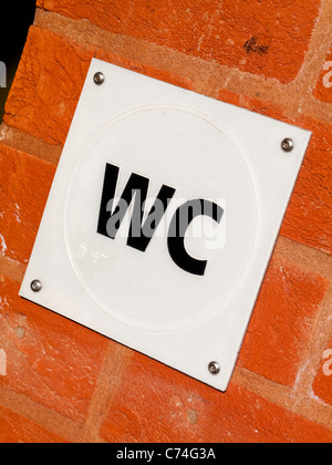 Tactile plastic sign outside public toilet with Braille text for visually impaired users Stock Photo