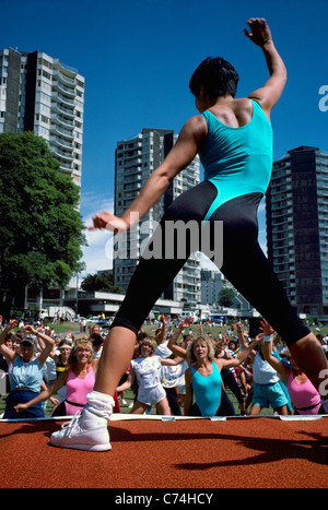 Woman exercising Outdoors and leading a Group of Adults in Outdoor Exercise Class, West End, Vancouver, British Columbia, Canada Stock Photo