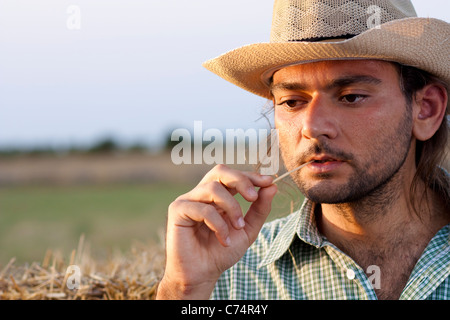 Farmer Thinking at Sunset with Straw in His Mouth Stock Photo