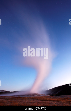 Old Faithful geyser erupting under twilight sky, Yellowstone National Park, Wyoming, USA Stock Photo