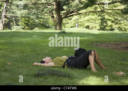 Woman relaxes on a lawn at the New York Botanical Garden in the Bronx, NYC. Stock Photo