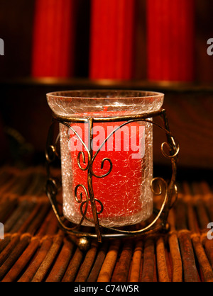 Decorative Christmas candle in a vase over a wooden area with warm light. Stock Photo