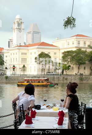 Two women drinking at a restaurant, Boat Quay on the banks of the Singapore river, Singapore Asia
