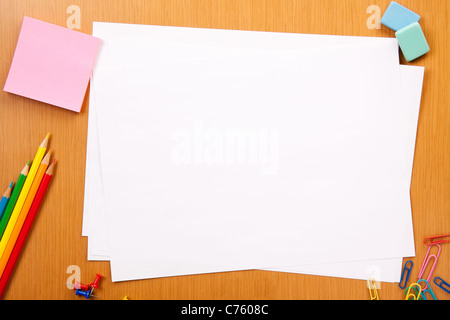 Set of pencils, erasers, post-its and other useful supplies for the school. There is a centered blank sheet for text writing Stock Photo