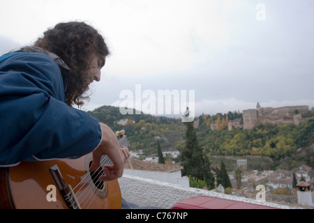 A young man plays guitar at the Mirador de San Nicolás in the Albaycin of Granada Stock Photo