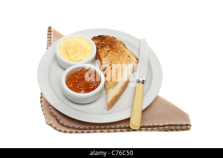 Toast, butter and marmalade on a plate with a knife and napkin isolated against white Stock Photo