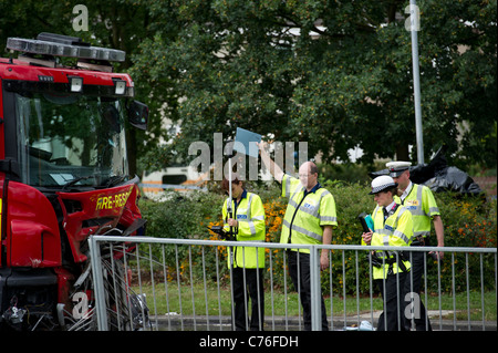 Police road traffic accident investigators taking measurements at a serious collision involving a fire engine and motor car. Stock Photo