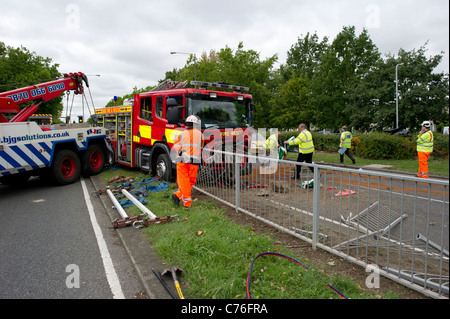 Police and recovery workers preparing to clear the scene of a serious road accident involving a fire engine and a car. Stock Photo