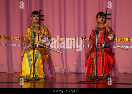 Two female musicians playing traditional stringed instruments at Tang dynasty dinner show, Xian, China Stock Photo