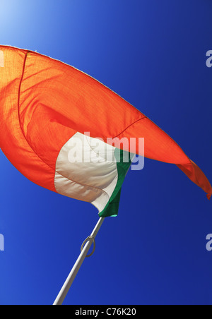National flag of Ireland on a flagpole in front of blue sky Stock Photo -  Alamy