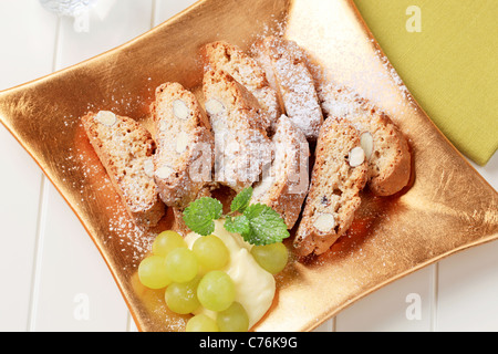 Traditional Italian almond biscotti with grapes and pudding Stock Photo