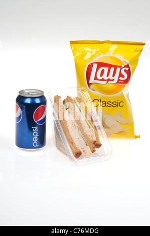 Takeaway lunch with Turkey and cheese on whole wheat bread sandwich packet, Lay's potato chips and Pepsi can on white background. Stock Photo