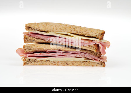 Halves of a ham and cheese sandwich on whole meal bread with lettuce stacked on white background, isolated. Stock Photo