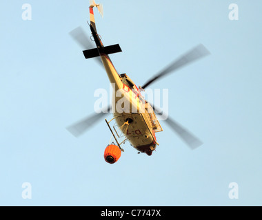 Bell 412 helicopter taking water to brush fire,Cabopino Golf, Costa del Sol, Malaga Province, Andalucia, Spain, Western Europe. Stock Photo