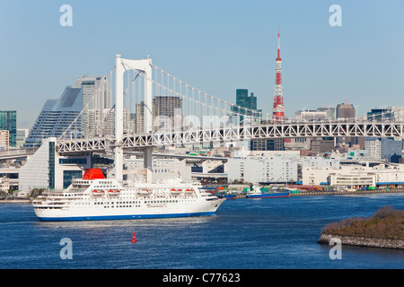 Asia, Japan, Honshu, Tokyo, Tokyo Bay, Odaiba, City skyline including a ship sailing under the Rainbow Bridge and Tokyo Tower Stock Photo