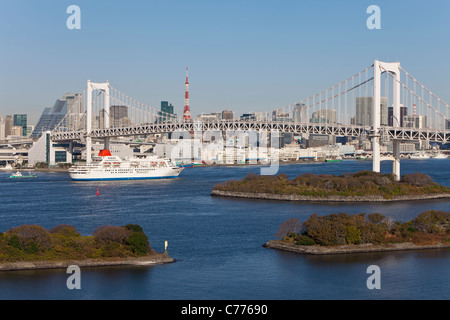 Asia, Japan, Honshu, Tokyo, Tokyo Bay, Odaiba, City skyline including a ship sailing under the Rainbow Bridge and Tokyo Tower Stock Photo