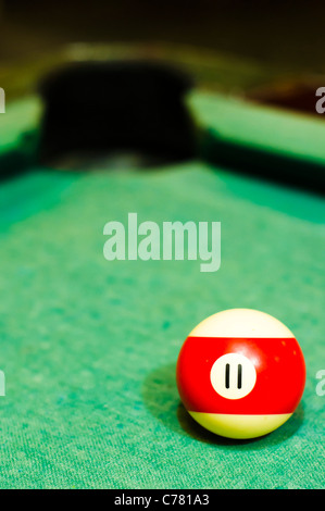 a close up of billiard ball number 11, red striped, for conceptual usage. Stock Photo