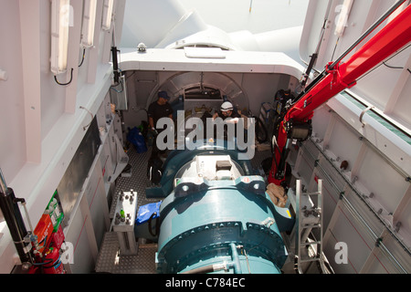 engineers working in the nacelle of a wind turbine in the Walney offshore wind farm. Stock Photo