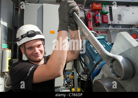 Engineers work in the nacelle of an offshore wind turbine to commission it, Walney offshore wind farm, Cumbria, UK. Stock Photo