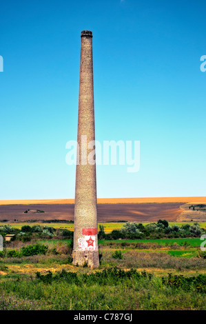 Remains from the communism- chimney with painter red star hammer and sickle Stock Photo