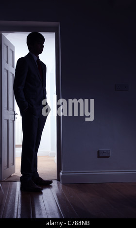 Silhouette of a man standing in front of an open door. Stock Photo