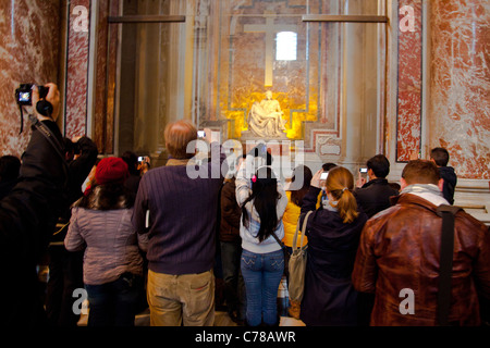 A crowd of visitors with many photographing Michelangelo's Pieta in St Peter's Basilica in the Vatican. Stock Photo