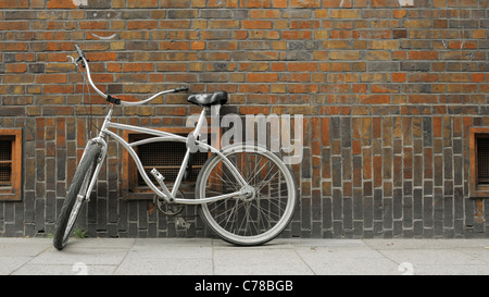 Bicycle leant to a brick wall. Hamburg. The picture is slightly desaturated. Format of the picture is 16*9. Stock Photo