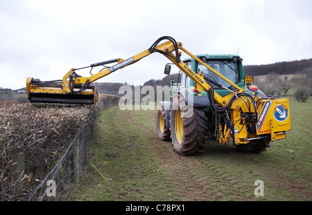 Tractor cutting hedges on farmland in south Wales. Stock Photo