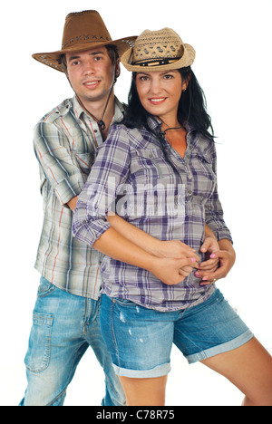Young couple wearing jeans,squares shirts and cowboy's hats and standing in embrace isolated on white background Stock Photo