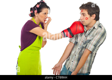 Angry housewife kicking with boxing glove her drunk unfaithful husband isolated on white background Stock Photo