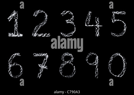 Handwritten numbers written on a blackboard in white chalk then cleaned up during editing and placed on a black background. Stock Photo