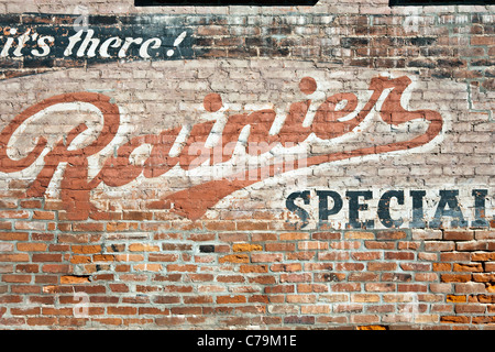 faded retro advertisement for Rainier ale painted on wall of old brick building in Bellingham Whatcom County Washington Stock Photo