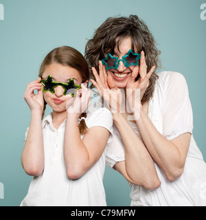 Studio shot of mother and daughter (10-11) wearing star shaped sunglasses Stock Photo
