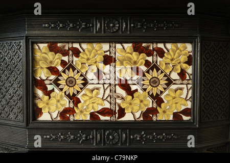 Victorian cast-iron fireplace with inlaid ceramic tiles. Stock Photo